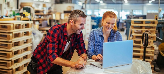 Man en vrouw bij een laptop in een magazijn