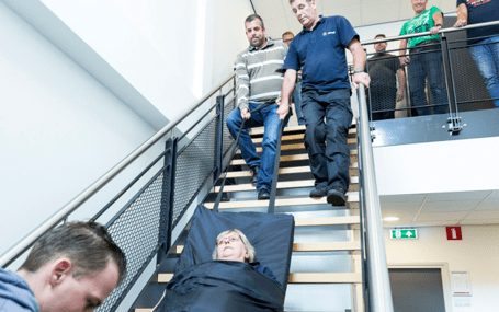 gewonde op mat naar beneden van de trap